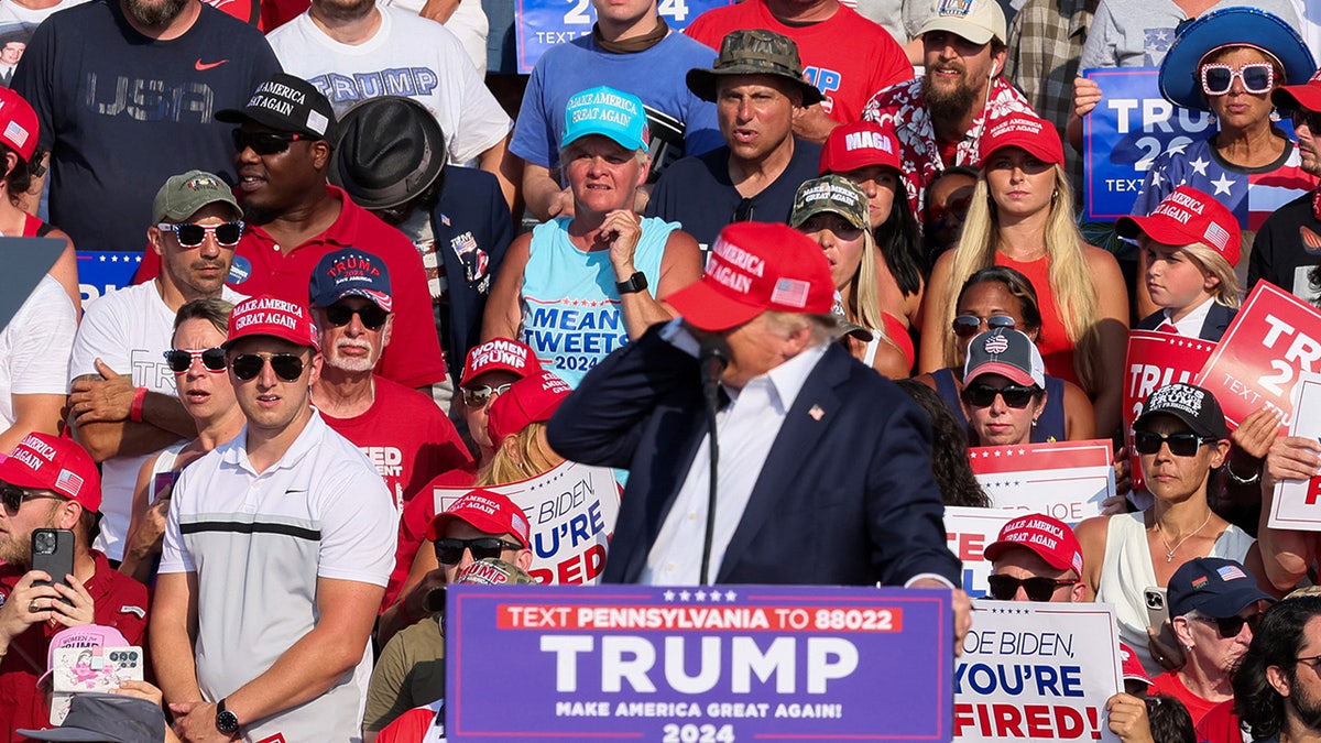 Republican presidential candidate and former U.S. President Donald Trump reacts as multiple shots rang out during a campaign rally