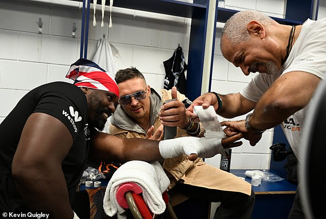 Chisora has his hands wrapped in preparation for the match, accompanied by heavyweight champion Oleksandr Usyk