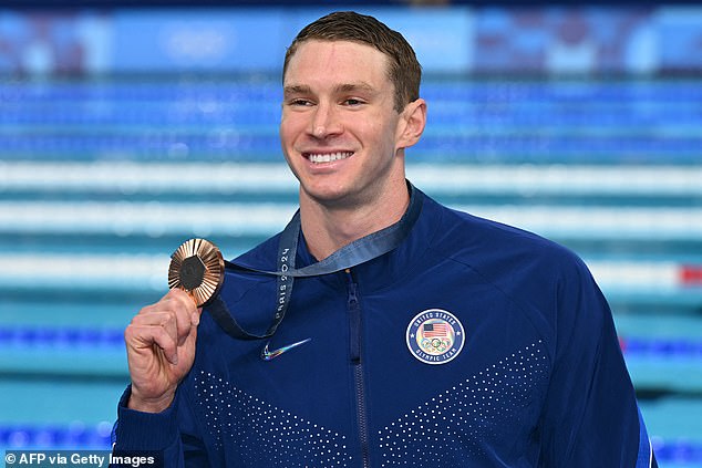 Ryan Murphy poses with his medal on the podium after the men's 100m backstroke final