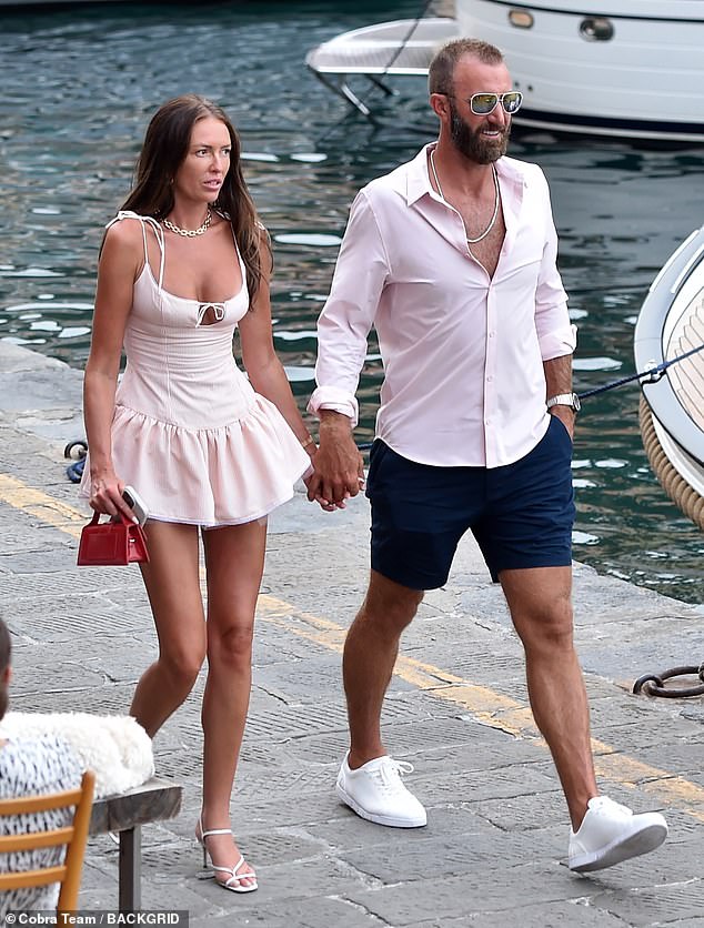 Dustin Johnson is seen walking hand-in-hand with wife Paulina Gretzky along the water in Italy