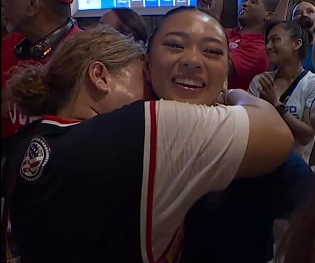 Suni Lee is seen being hugged by her mother after they reunited following the gold medal