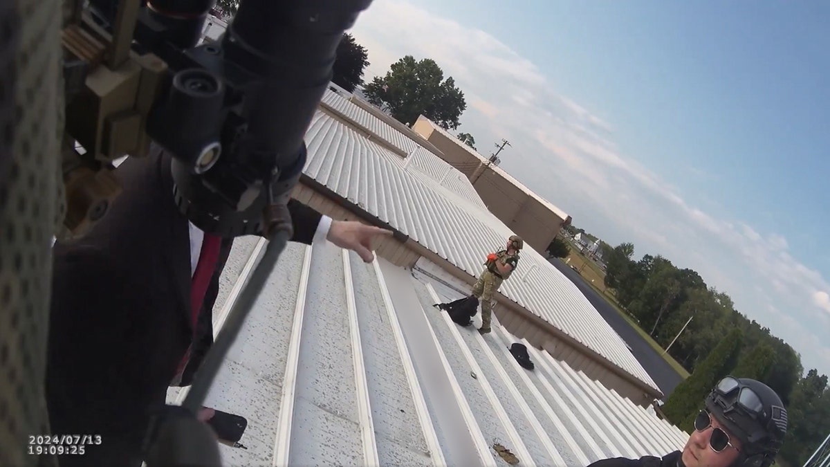 Beaver County Emergency Services officers and a Secret Service agent communicate on the roof of the building where Thomas Crooks aimed at former President Trump.