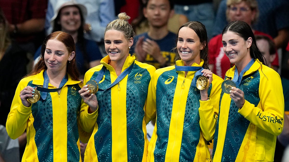 Australian swimmers displaying their gold medals