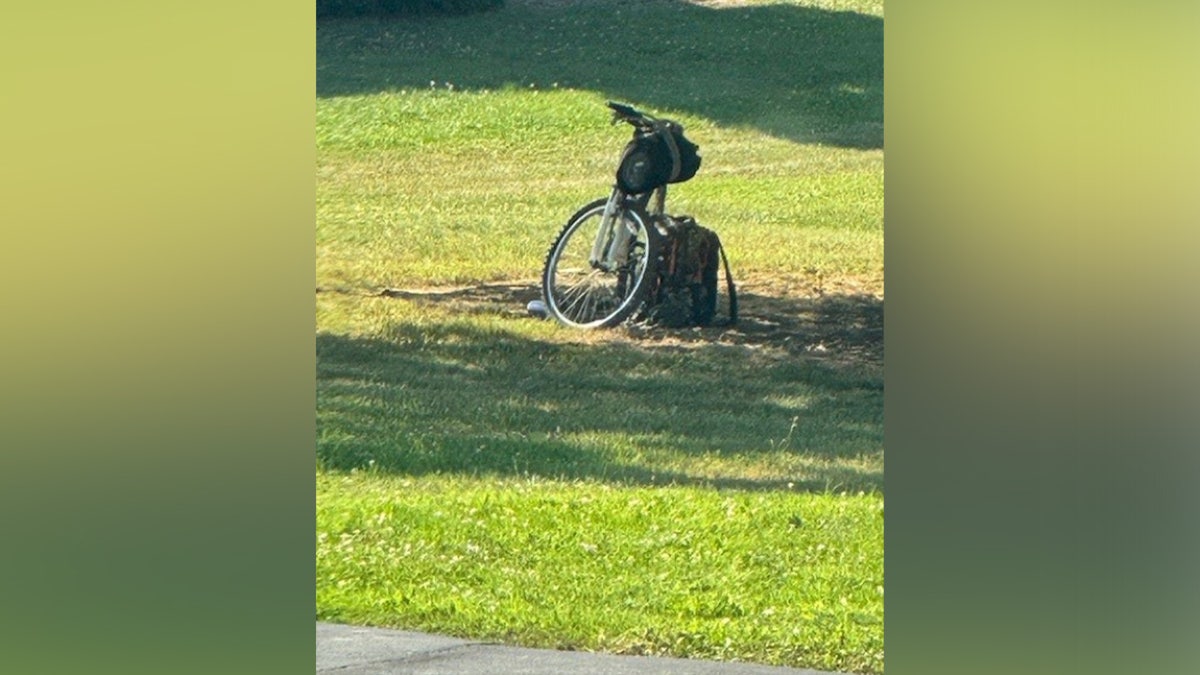 An evidence photo showing Thomas Crooks' abandoned bicycle and backpack before his assassination attempt on former President Donald Trump