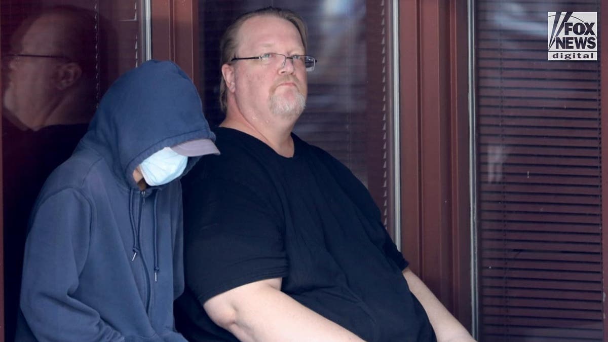 Matthew Crooks, the father of the would-be assassin, waits outside an office building