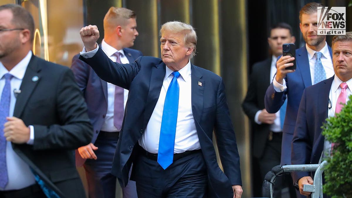 Donald Trump arriving at court with fist raised in air