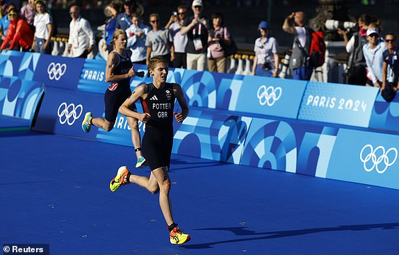 Paris 2024 Olympics - Triathlon - Mixed Relay - Paris, France - August 05, 2024. Beth Potter of Britain and Taylor Knibb of United States in action. REUTERS/Piroschka Van De Wouw