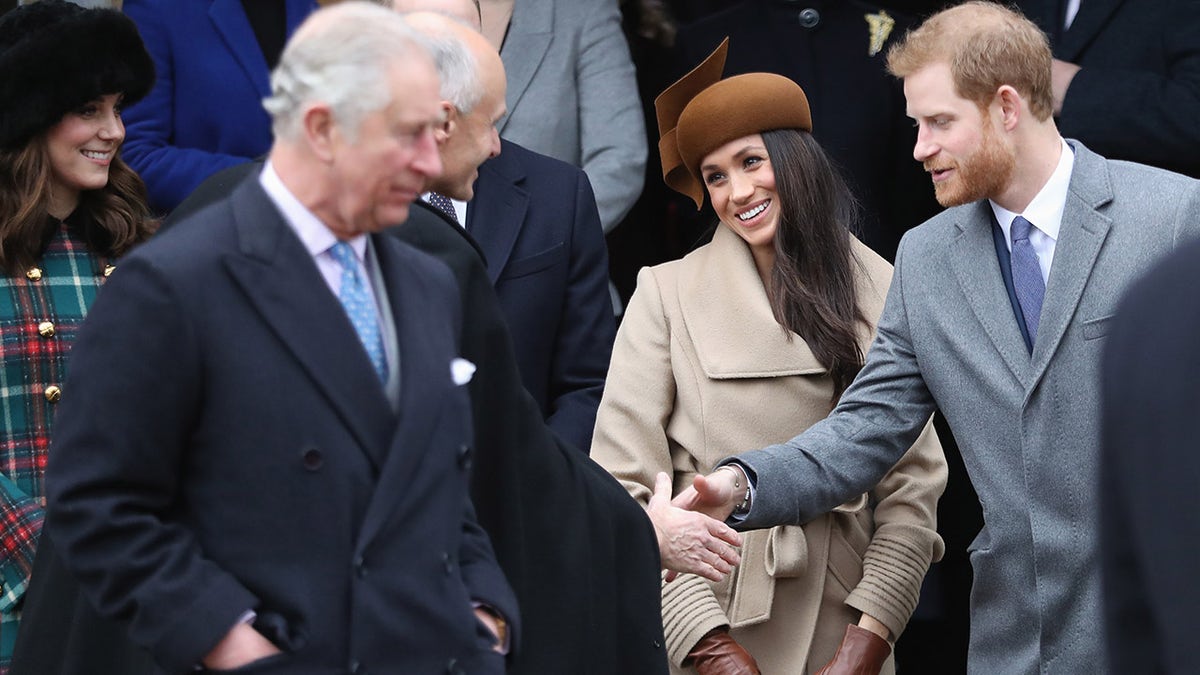 King Charles appears detached as Prince Harry and Meghan Markle greet an elder gentleman.