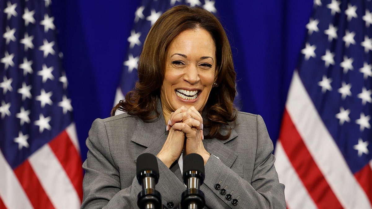 Kamala Harris with US flags behind her