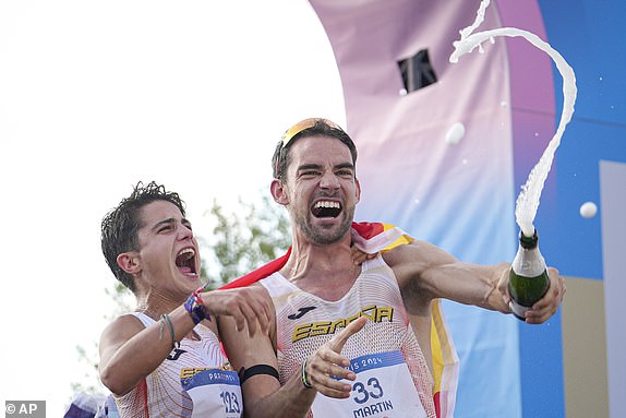 Spain's Maria Perez and Alvaro Martin celebrate after winning the gold medal in the marathon race walk relay mixed at the 2024 Summer Olympics in Paris, August 7, 2024. (AP Photo/Vadim Ghirda)