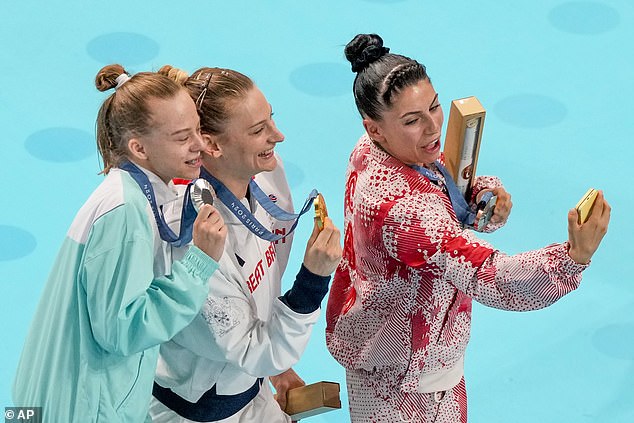 The three medalists pictured posing for a group selfie on the Olympic podium on Friday