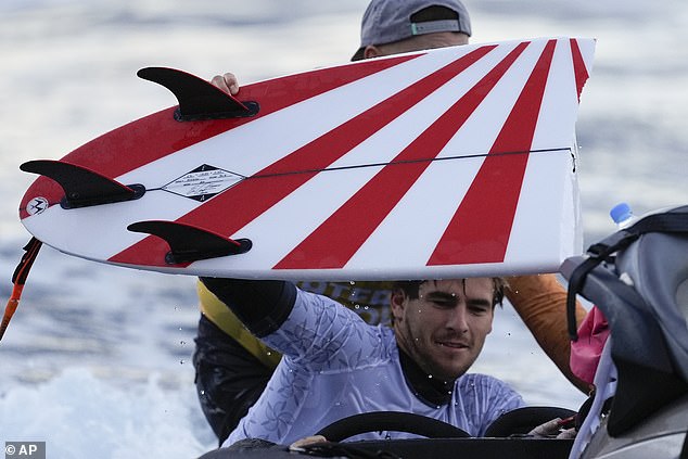 Robinson (pictured after breaking one of his boards) inadvertently offended South Koreans with his red rising sun design