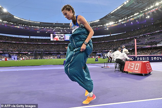 Yaroslava Mahuchikh bundled up in a sleeping bag between jumps at the Paris Olympics