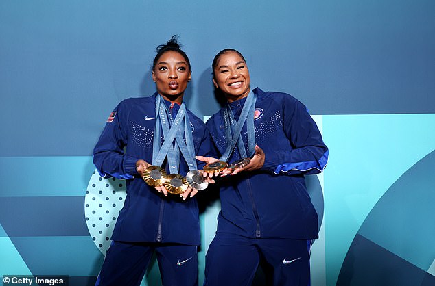 Biles poses with USA teammate Jordan Chiles and her four Olympic medals in Paris