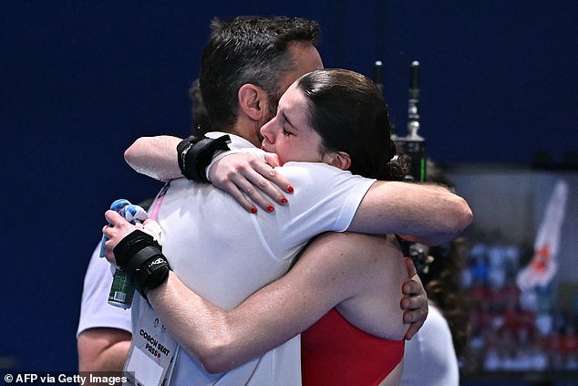 The tearful Team GB star receives a big hug from her coach after missing out on a medal