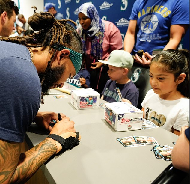 Mariners shortstop JP Crawford signs a card for the kids before Tuesday's game