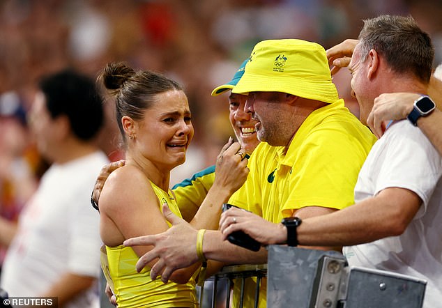 The Australian was beside herself with emotion as she hugged her coach and team (pictured) after her stunning victory