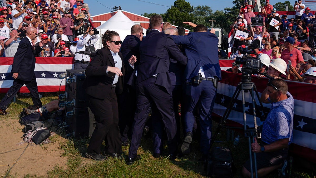 Donald Trump surrounded by U.S. Secret Service agents at a campaign rally