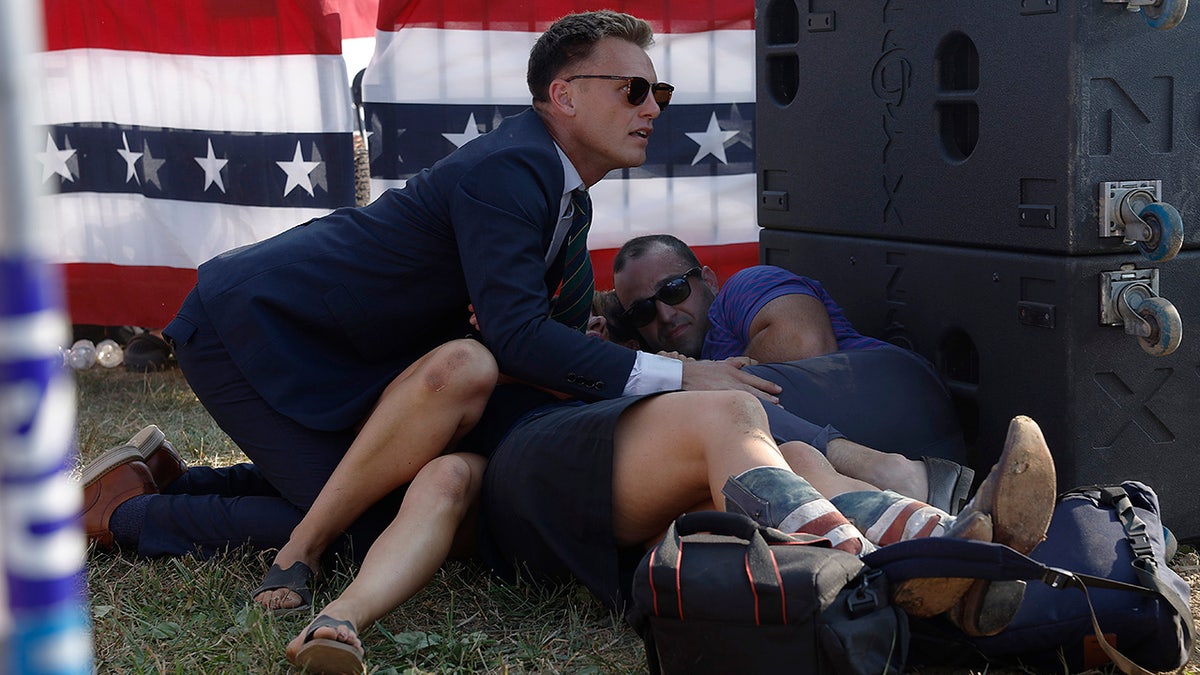 A Secret Service member and attendees are seen at Donald Trump's rally