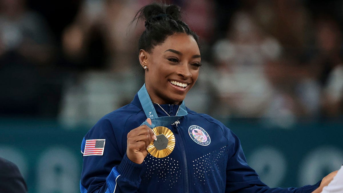 Gold medalist Simone Biles of Team United States on the podium during the Artistic Gymnastics Women's All-Around Final medal ceremony on day six of the Olympic Games Paris 2024 at Bercy Arena on August 1, 2024 in Paris.