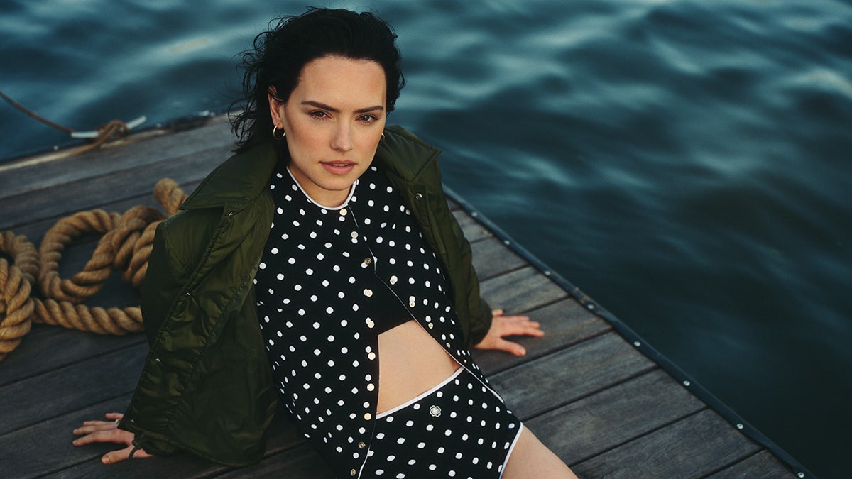 Daisy Ridley in a polka dot cardigan and matching bottoms by the lake.