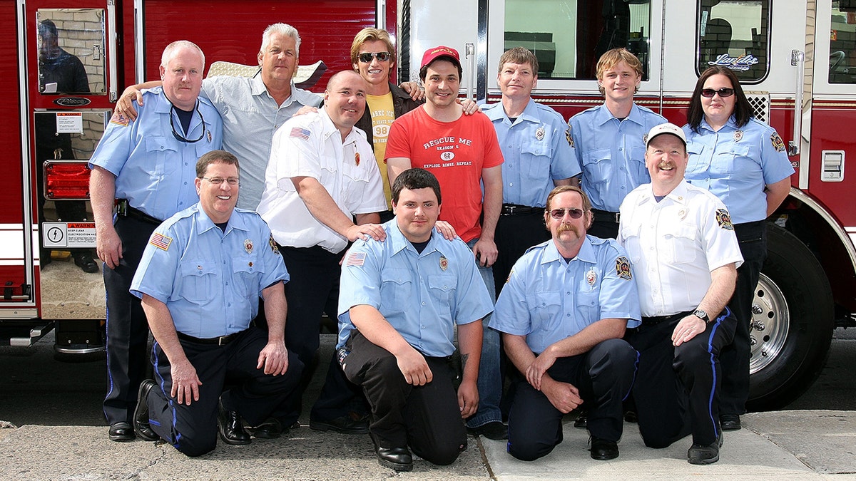 Actors Denis Leary, Adam Ferrara, and Lenny Clarke posed with firefighters in blue uniforms